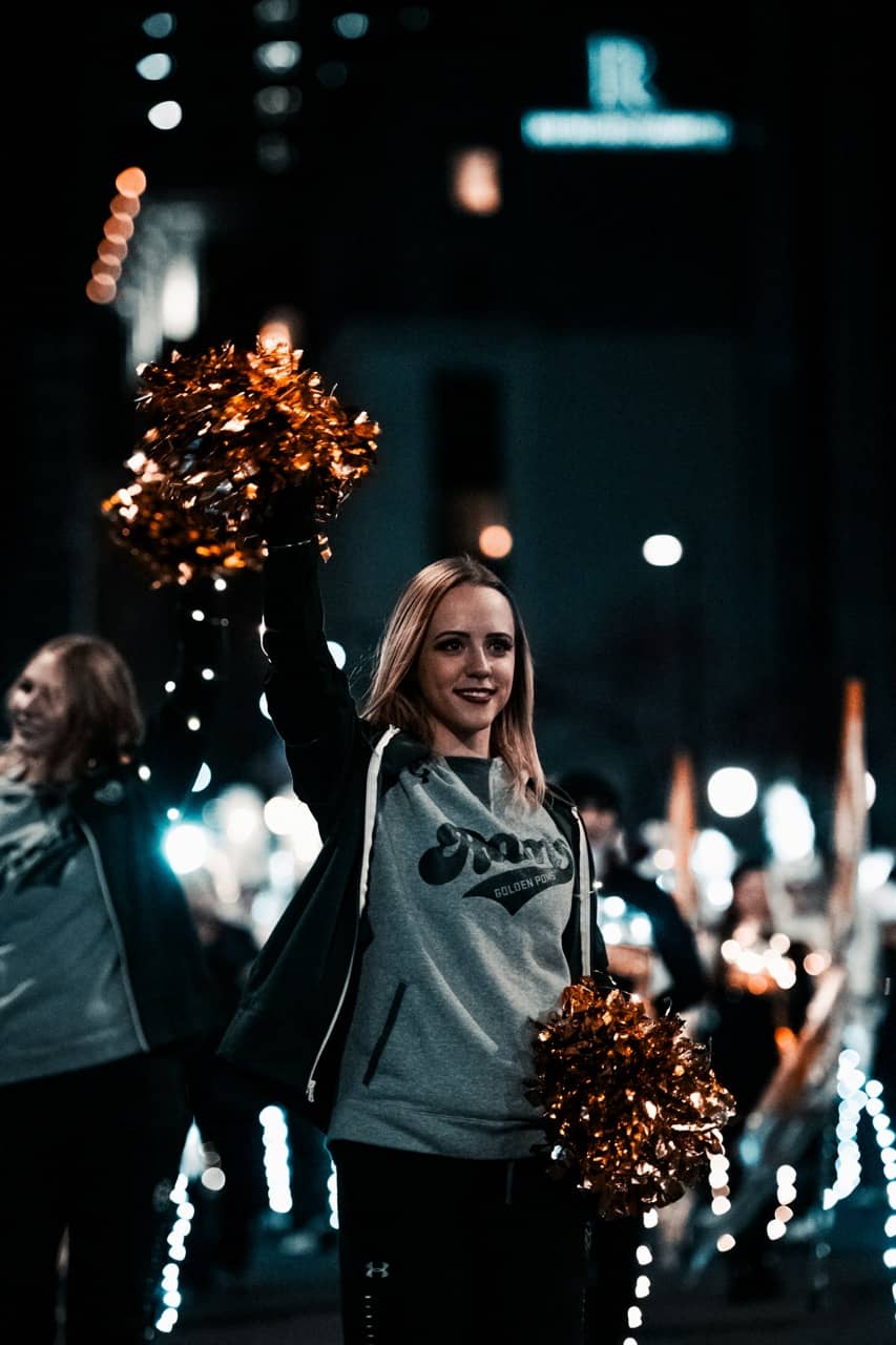 college dance team member holding pom poms